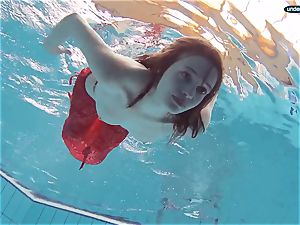 crimson clad teen swimming with her eyes opened